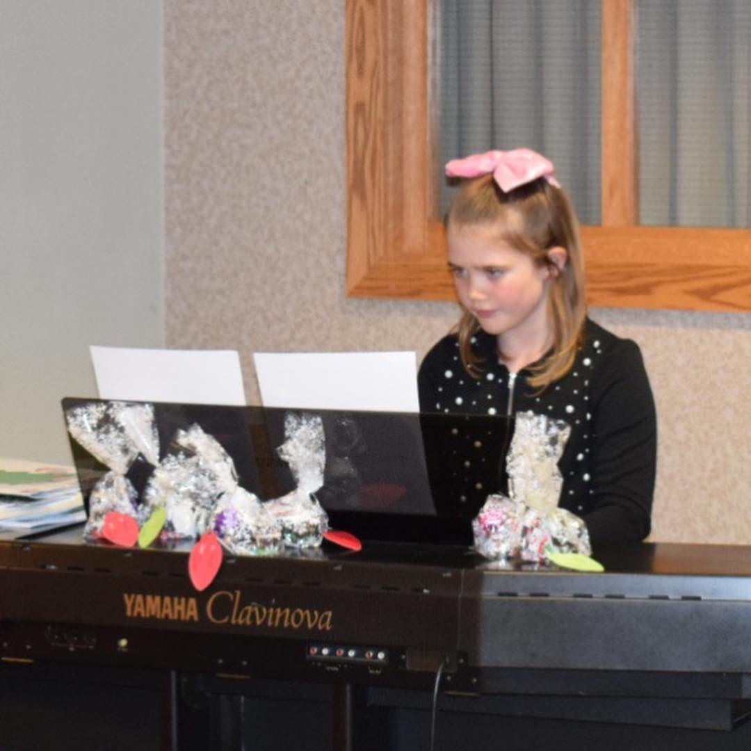 Sophie playing Sing We Now of Christmas on the piano.